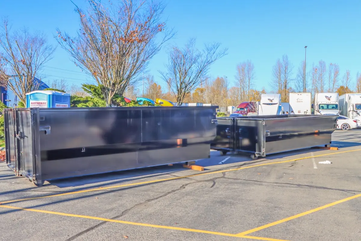 Professional dumpster rental service with roll-off container on residential driveway in Reynolds